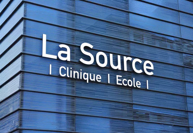Logo La Source Clinique et Ecole sur façade, de nuit